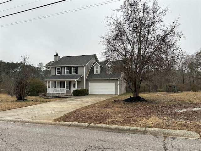 colonial-style house featuring covered porch and a garage