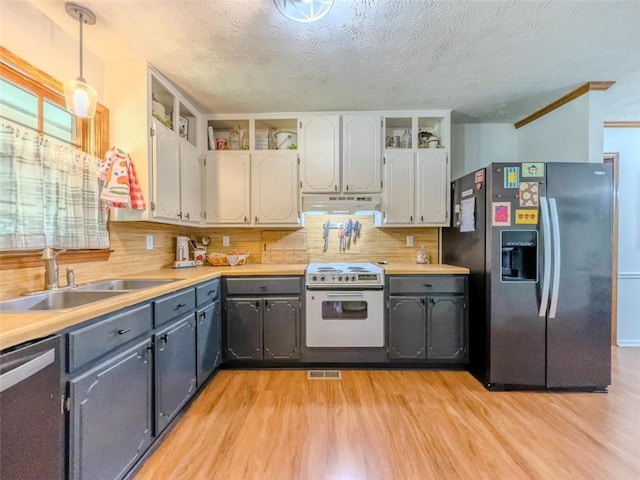 3769 Bay Creek Church Rd, Loganville, GA 30052 - kitchen with black fridge with ice dispenser, white range with electric cooktop, under cabinet range hood, a sink, and light wood finished floors