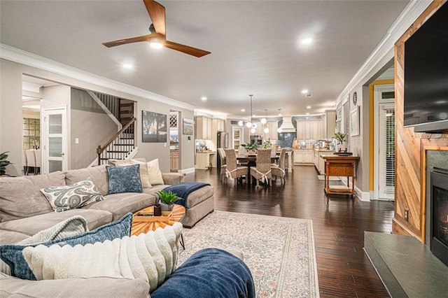 4435 Mossbrook Cir, Alpharetta, GA 30004 - living area featuring ceiling fan, ornamental molding, stairway, dark wood-type flooring, and a lit fireplace