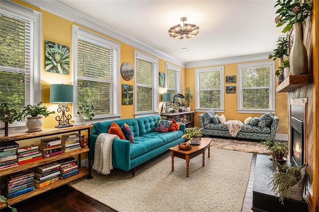 4435 Mossbrook Cir, Alpharetta, GA 30004 - living room featuring crown molding, wood finished floors, plenty of natural light, a chandelier, and a warm lit fireplace