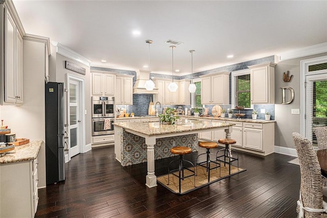 4435 Mossbrook Cir, Alpharetta, GA 30004 - kitchen featuring appliances with stainless steel finishes, a center island, a breakfast bar, custom range hood, and tasteful backsplash