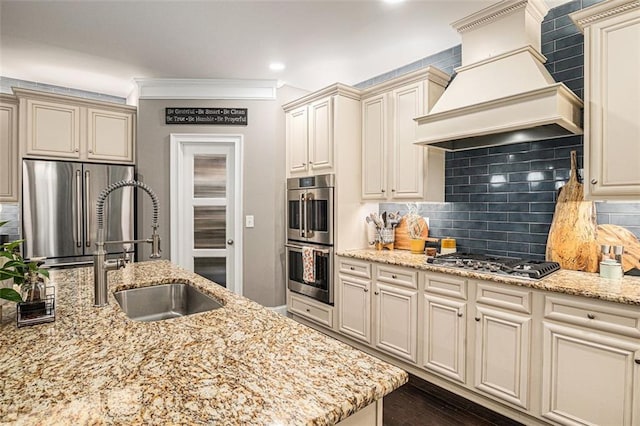 4435 Mossbrook Cir, Alpharetta, GA 30004 - kitchen featuring appliances with stainless steel finishes, custom exhaust hood, cream cabinetry, a sink, and crown molding