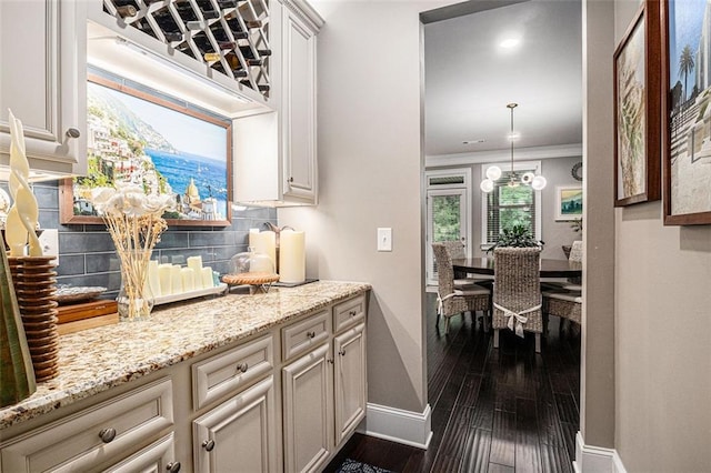 4435 Mossbrook Cir, Alpharetta, GA 30004 - kitchen with baseboards, decorative backsplash, dark wood finished floors, light stone counters, and ornamental molding