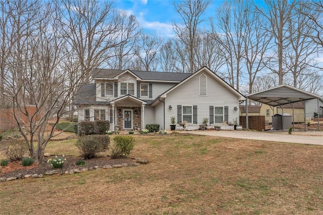 traditional-style house featuring an outbuilding, fence, driveway, stone siding, and a front lawn