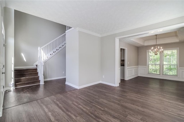 unfurnished living room featuring stairs, a raised ceiling, baseboards, a notable chandelier, and dark wood-type flooring