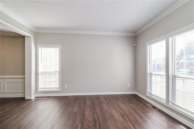 unfurnished room with visible vents, a textured ceiling, ornamental molding, and dark wood finished floors
