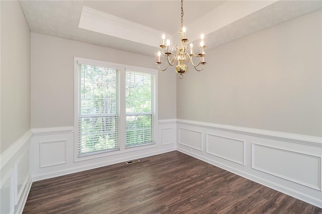 spare room with visible vents, dark wood-style floors, a notable chandelier, and wainscoting