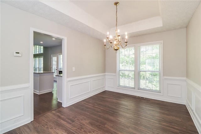 unfurnished dining area with dark wood-style floors, an inviting chandelier, visible vents, a decorative wall, and wainscoting