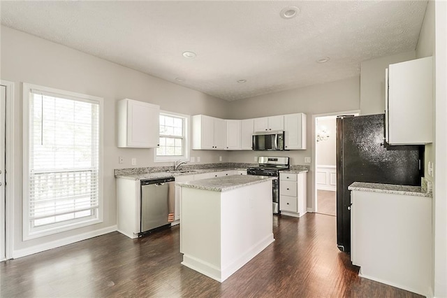 kitchen featuring white cabinets, dark wood finished floors, a kitchen island, and stainless steel appliances