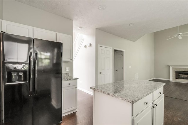 kitchen with ceiling fan, black fridge, dark wood-type flooring, and white cabinets
