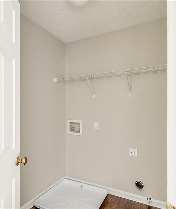 laundry area with dark wood-style floors, hookup for an electric dryer, baseboards, hookup for a washing machine, and laundry area