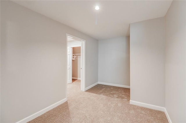 empty room featuring light colored carpet and baseboards