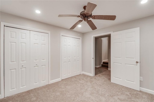 unfurnished bedroom featuring light colored carpet, baseboards, multiple closets, and recessed lighting