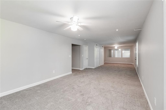 carpeted empty room with ceiling fan and baseboards