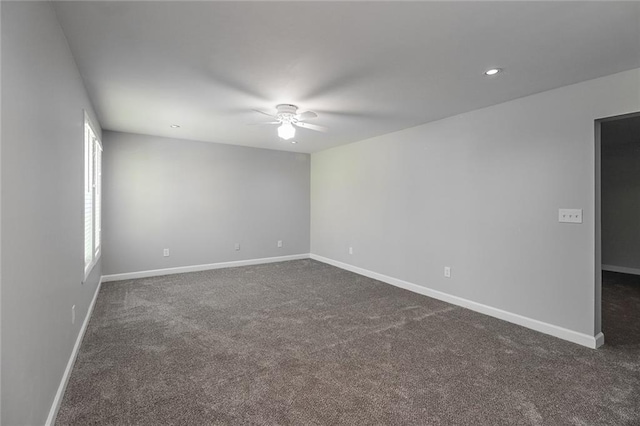 unfurnished room featuring ceiling fan, baseboards, and dark colored carpet