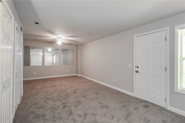 empty room featuring carpet, a ceiling fan, and baseboards