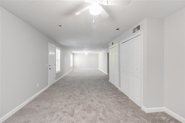corridor featuring visible vents, baseboards, and carpet floors