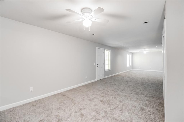 carpeted empty room featuring baseboards and ceiling fan