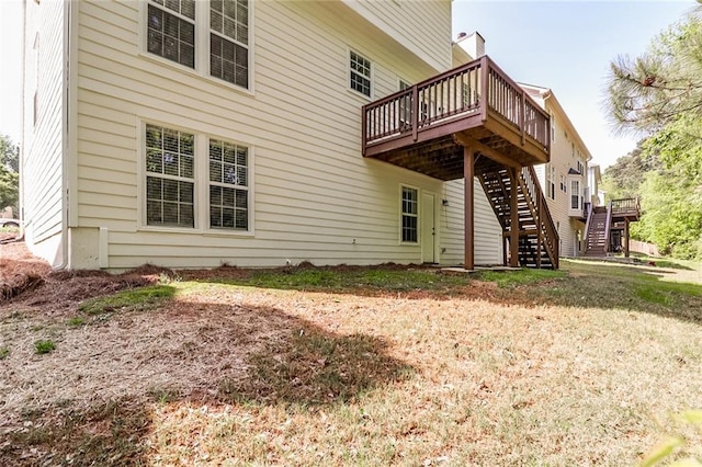 back of property with a wooden deck and stairway