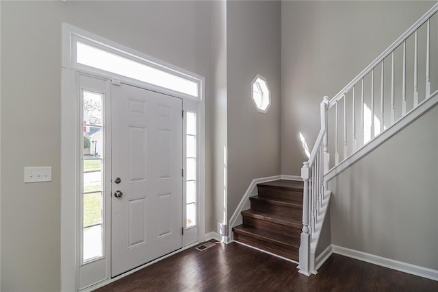 foyer entrance featuring baseboards, dark wood-style floors, and stairway
