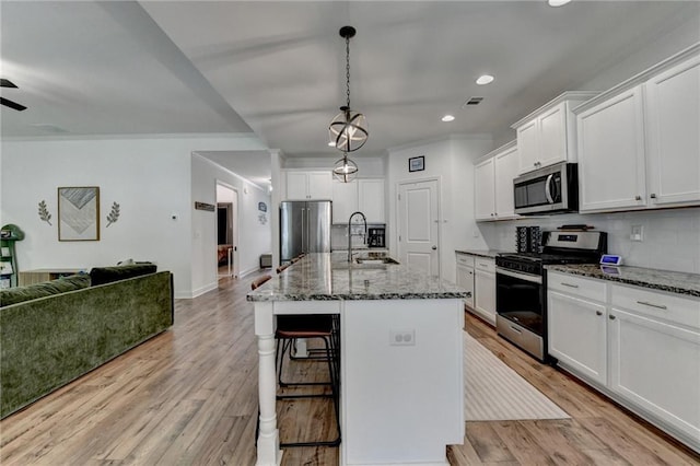 2129 Charmond Dr, Monroe, GA 30656 - kitchen featuring stainless steel appliances, open floor plan, light wood-type flooring, a breakfast bar area, and recessed lighting