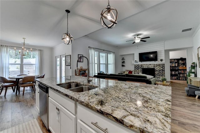 2129 Charmond Dr, Monroe, GA 30656 - kitchen with dishwasher, open floor plan, a brick fireplace, healthy amount of natural light, and ornamental molding