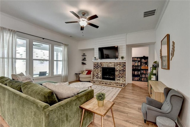 2129 Charmond Dr, Monroe, GA 30656 - living room featuring a ceiling fan, ornamental molding, a fireplace, and light wood-type flooring