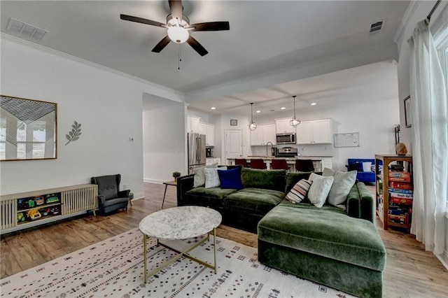 2129 Charmond Dr, Monroe, GA 30656 - living area featuring light wood-style flooring, recessed lighting, a ceiling fan, and ornamental molding