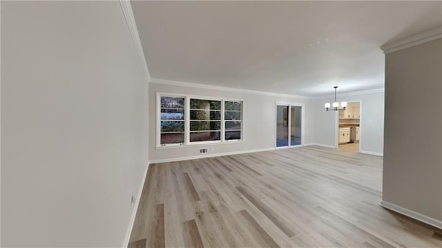 unfurnished living room with crown molding, light hardwood / wood-style flooring, and a chandelier