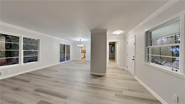 unfurnished room featuring ornamental molding, light wood-type flooring, and an inviting chandelier