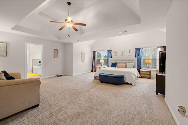 bedroom with a raised ceiling, visible vents, and baseboards