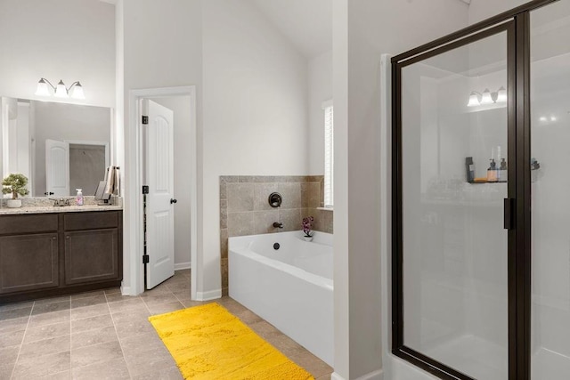 bathroom with a garden tub, tile patterned flooring, a stall shower, and vanity