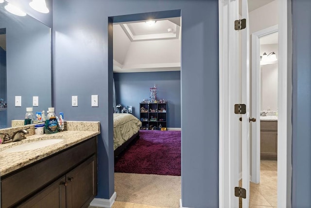 bathroom with tile patterned flooring, vanity, and ensuite bathroom