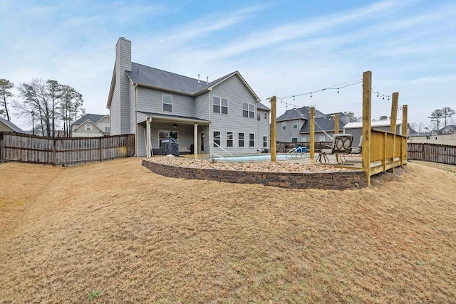 back of property with a chimney, fence, and a patio