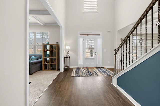 foyer featuring a high ceiling, stairway, wood finished floors, and baseboards