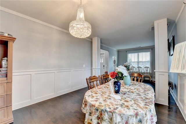 dining room featuring a chandelier, crown molding, and dark wood-type flooring