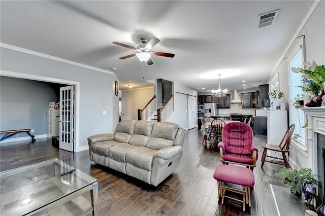 living room featuring ceiling fan with notable chandelier, ornamental molding, dark wood-type flooring, and a wealth of natural light