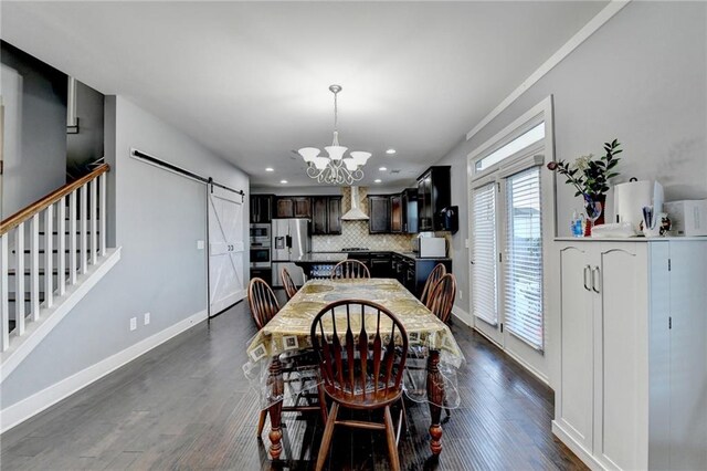 dining room with a notable chandelier, a barn door, and dark wood-type flooring