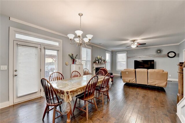 dining space with plenty of natural light, ceiling fan with notable chandelier, dark hardwood / wood-style floors, and ornamental molding