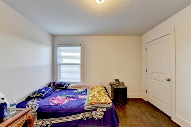 bedroom with dark hardwood / wood-style floors