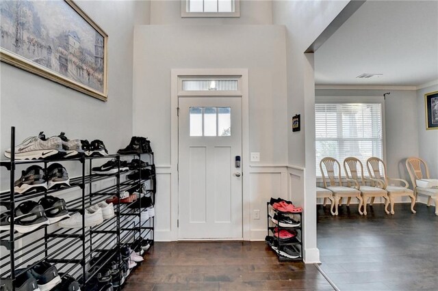 foyer with plenty of natural light, dark hardwood / wood-style flooring, and crown molding