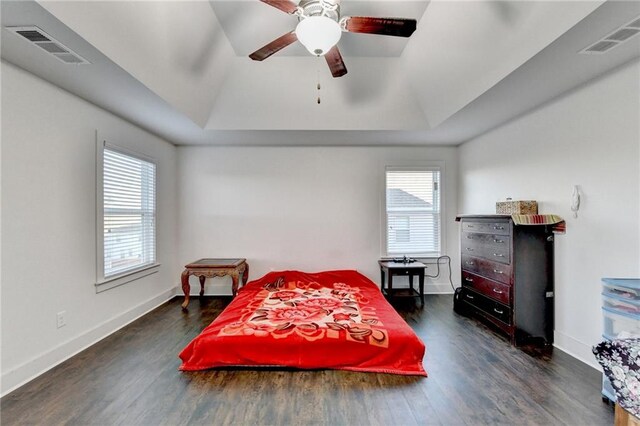 bedroom featuring dark hardwood / wood-style floors, multiple windows, lofted ceiling, and ceiling fan