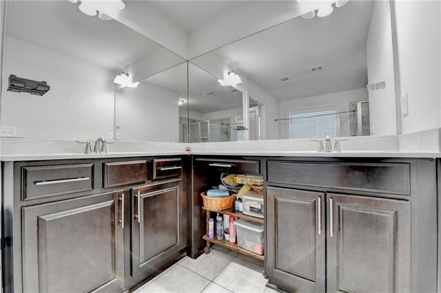 bathroom with tile patterned floors, vanity, and a shower with door