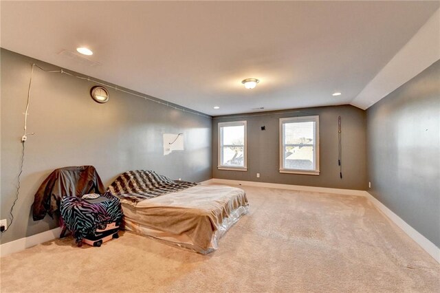 bedroom with carpet floors and lofted ceiling