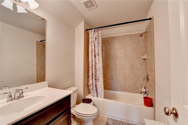 full bathroom with tile patterned floors, shower / bathtub combination with curtain, vanity, and toilet