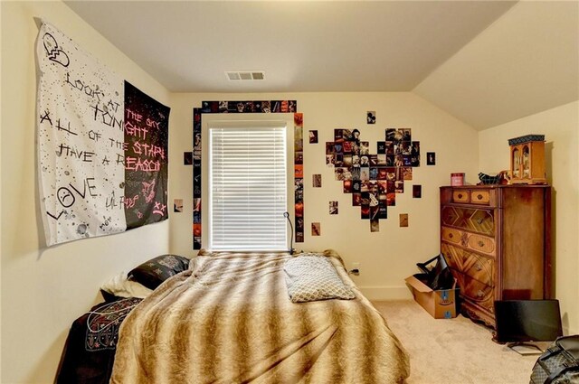 bedroom with carpet floors and lofted ceiling