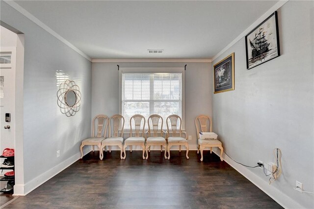 sitting room with crown molding and dark wood-type flooring