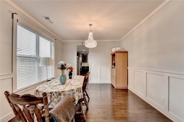 dining space with dark hardwood / wood-style flooring, crown molding, and a notable chandelier