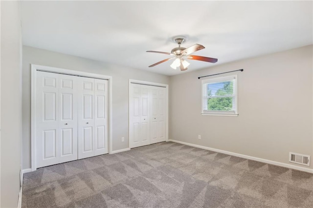 1231 Sanden Ferry Dr, Decatur, GA 30033 - unfurnished bedroom with carpet floors, two closets, visible vents, ceiling fan, and baseboards