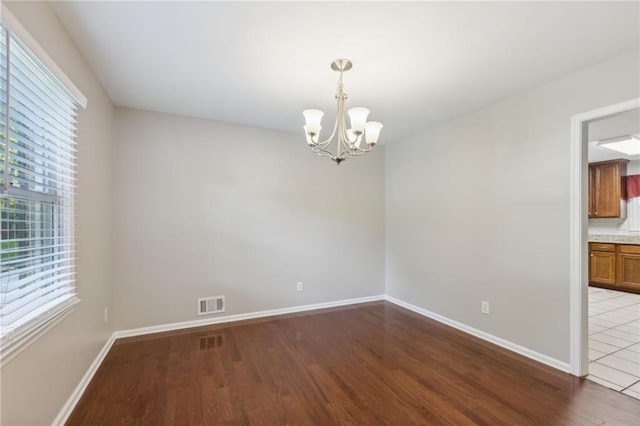 1231 Sanden Ferry Dr, Decatur, GA 30033 - empty room with an inviting chandelier, baseboards, visible vents, and wood finished floors